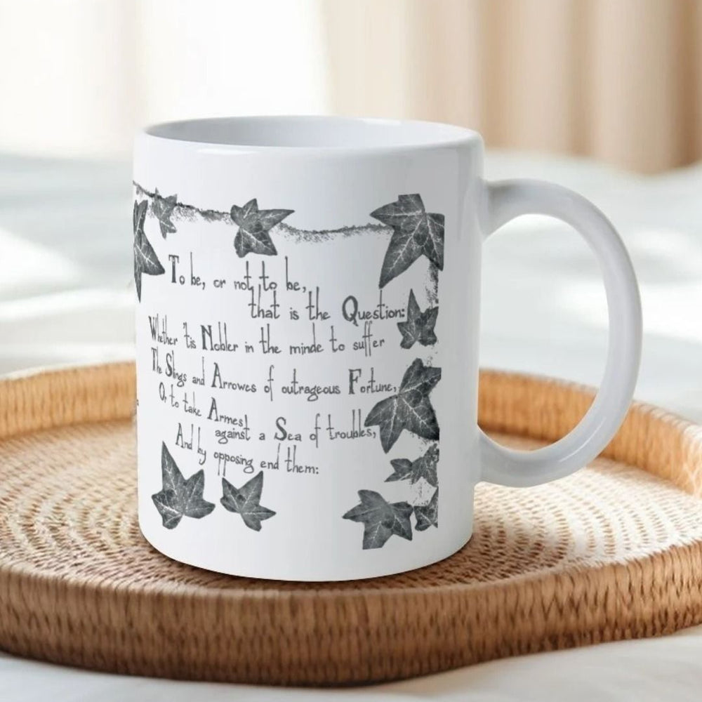 White mug with grey leafy graphics with scratchy 'to be' quotes text on either side