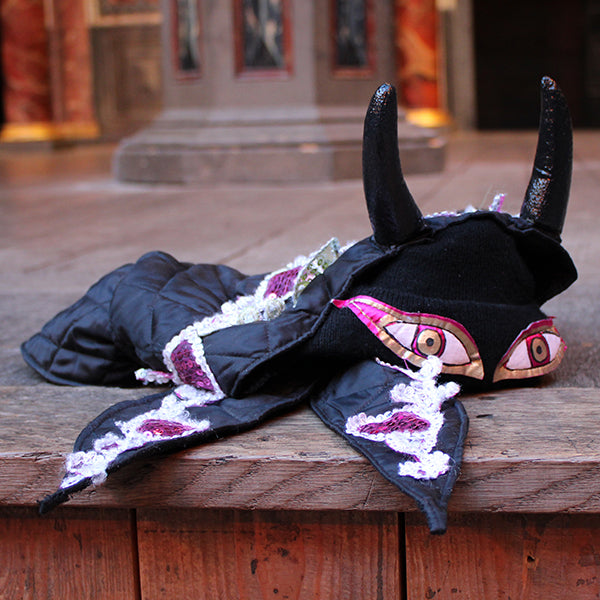 Black costume with decorative elements on a wooden surface