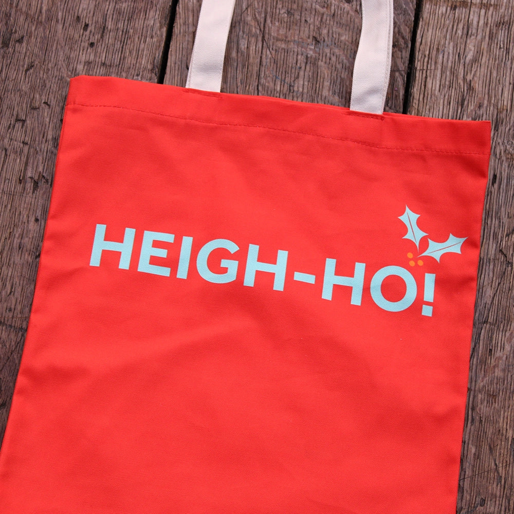 Cherry red tote bag with natural handles and pale blue graphic text