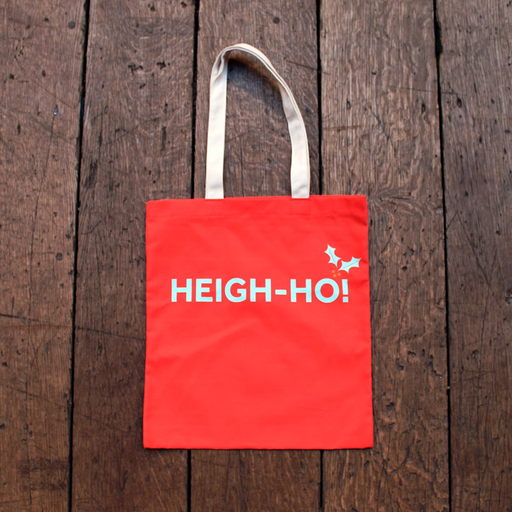 Cherry red tote bag with natural handles and pale blue graphic text