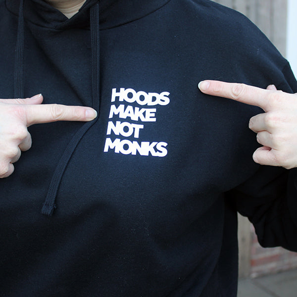 Black cotton hoodie with front pockets and a print on the upper left chest of a quote in heavy white text