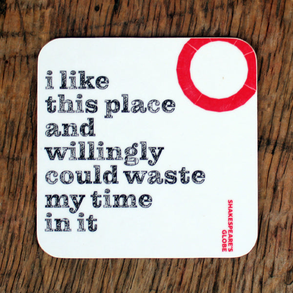 Coaster with text 'i like this place and willingly could waste my time in it' on a wooden surface, featuring the Shakespeare's Globe logo.