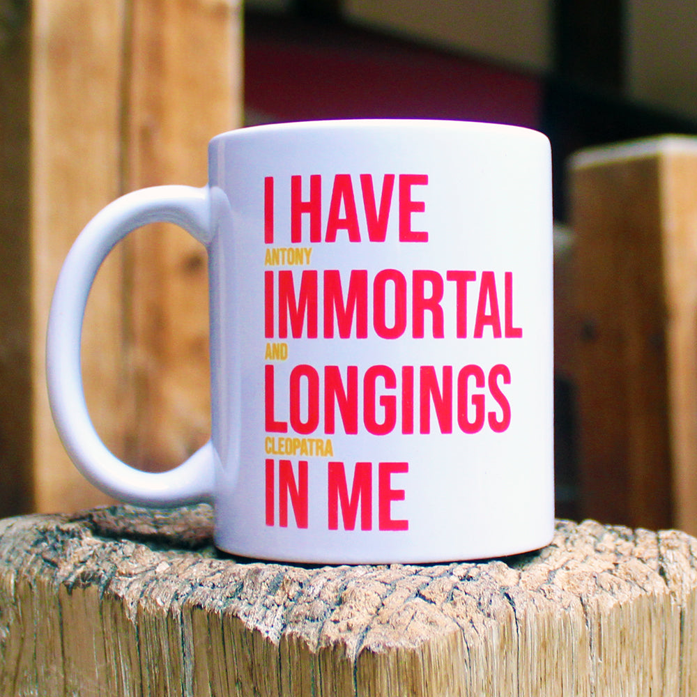 
                  
                    White ceramic mug with a red and yellow text print
                  
                
