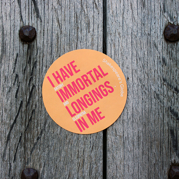 Yellow orange circular sticker with red and white graphic text on it