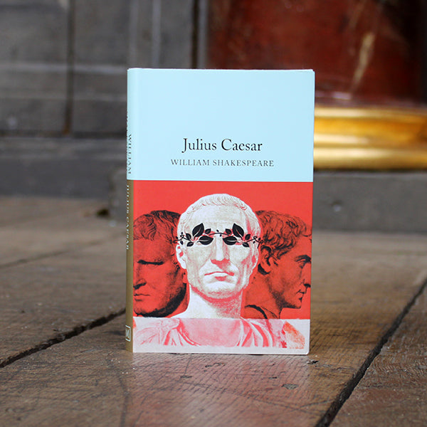 Hardback book with paper sleeve, pale blue on top and red on bottom with classical male statue