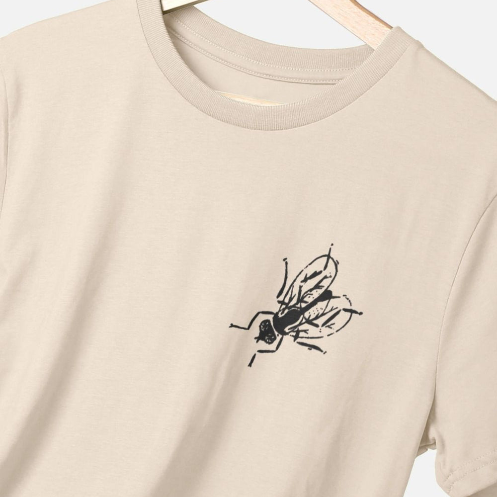 
                  
                    Standard fit cotton t-shirt with black fly graphic on upper left chest on oat t-shirt
                  
                