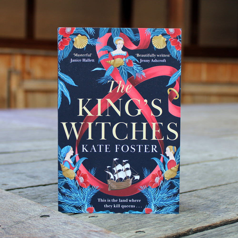 paperback book with a blue and red cover standing on a wooden stage