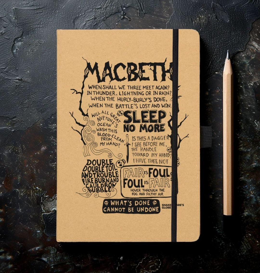 Kraft notebook with black graphic text quotes depicting Macbeth, with elastic closure on left hand side and on black mottled background with sharpened pencil