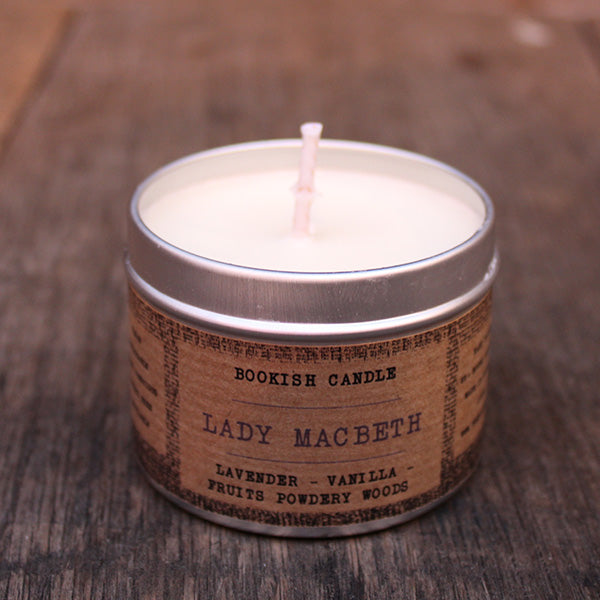 
                  
                    White potted candle in silver tin with tan coloured label surround with old time black print
                  
                