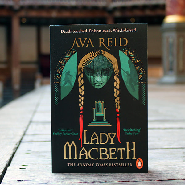 Black paperback book with image of woman's face on front cover, with long blonde braids dipped in blood, with gold text