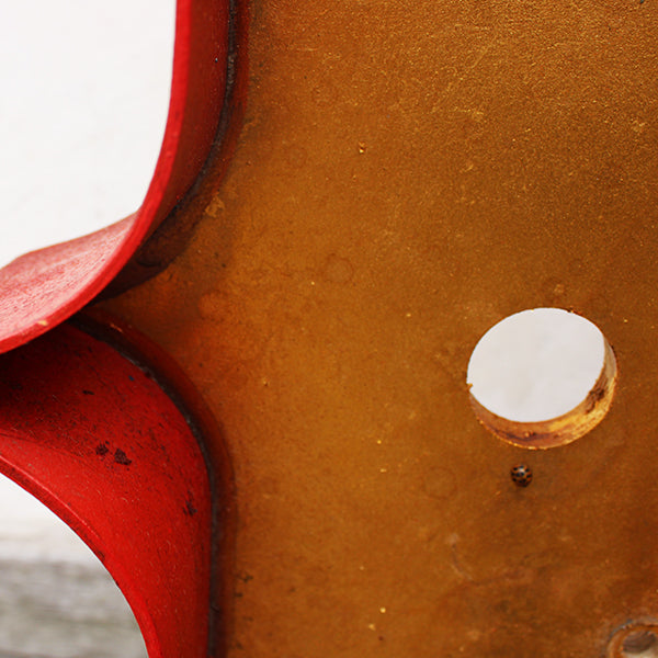 Close-up of a wooden letter with a red surround against a white background