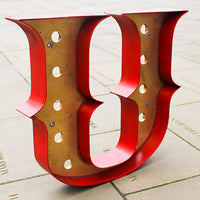 gold vintage letter with a red surround on a stone surface