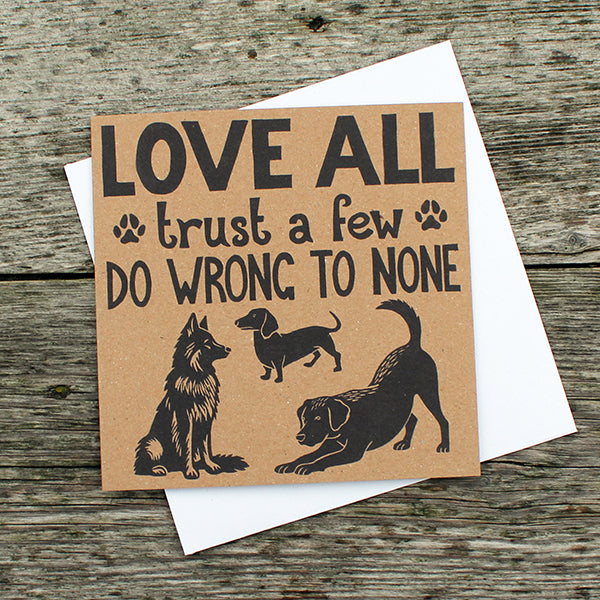 Card with text 'Love all, trust a few, do wrong to none' and dog illustrations on a wooden surface.