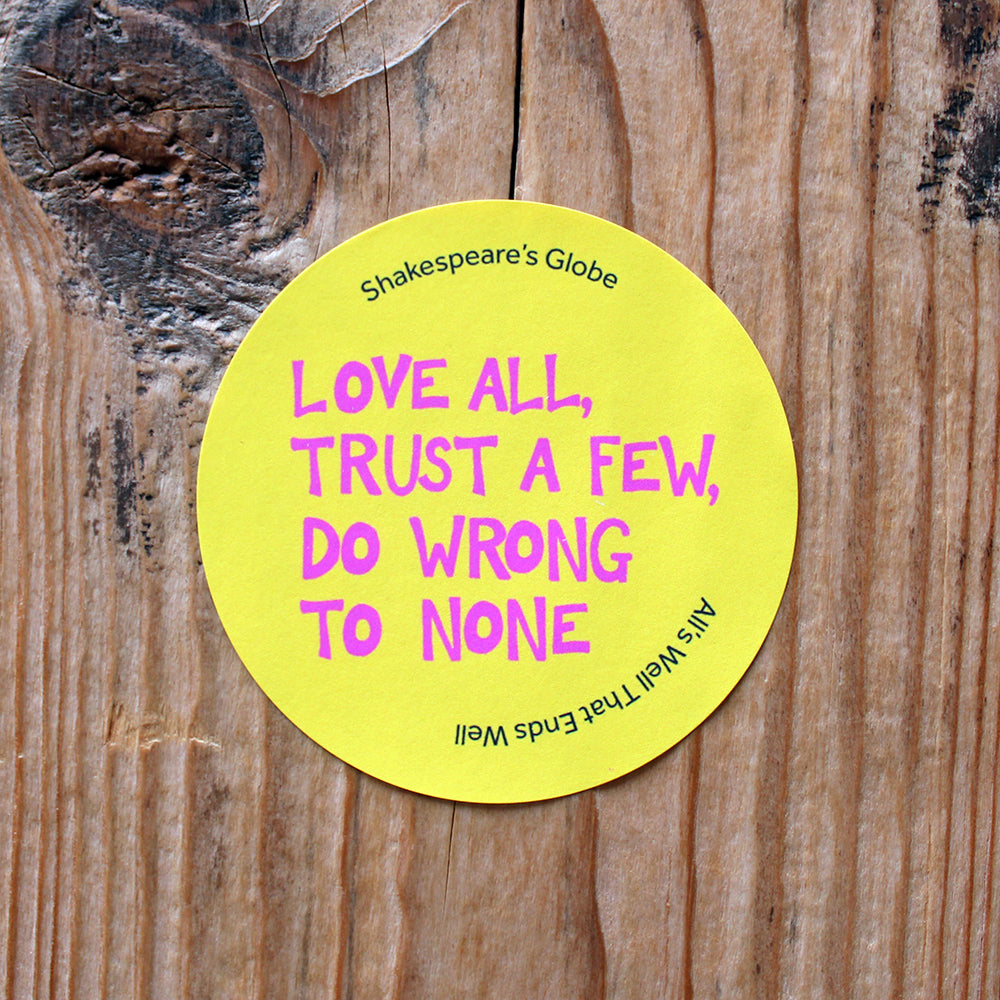 
                  
                    Yellow circular sticker with hot pink graphic text all over print, stuck on wood
                  
                