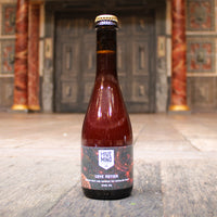 Bottle of 'Hive Mind Love Potion' on a wooden surface with a decorative background