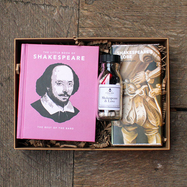 Gift set with 'The Little Book of Shakespeare' and a bottle labeled 'Shakespeare & Love' on a wooden surface.