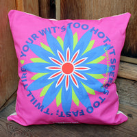 pink cushion with a large blue flower print on a wooden surface