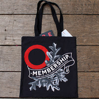 Natural wood flood with black graphic tote bag with Globe membership logo in white and red Globe logo