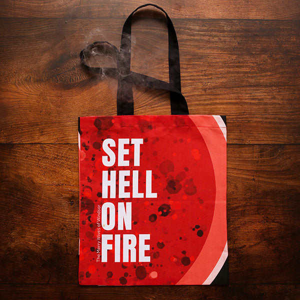 Red tote bag with all over bubbling fire graphic and block white text, with 2 black handles