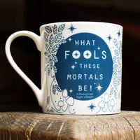 White mug with blue text and design on a wooden surface