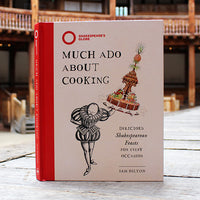 Cookbook with a cream cover and a red spine on a wooden stage