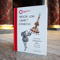 Book titled 'Much Ado About Cooking' by Sam Bilton on a wooden surface with a blurred background.