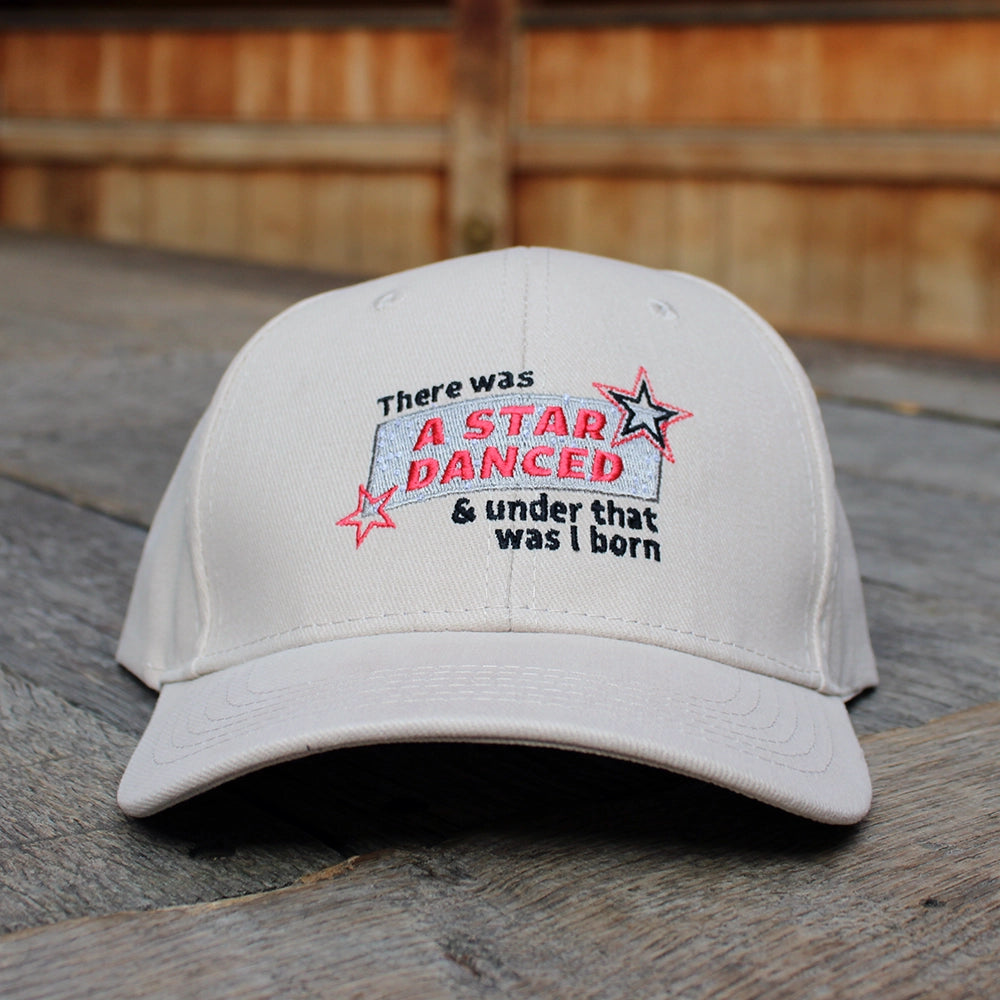 Sand coloured cotton baseball cap with red, black, and silver embroidery on the front