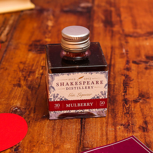 Bottle of Shakespeare Distillery Mulberry Gin Liqueur on a wooden surface