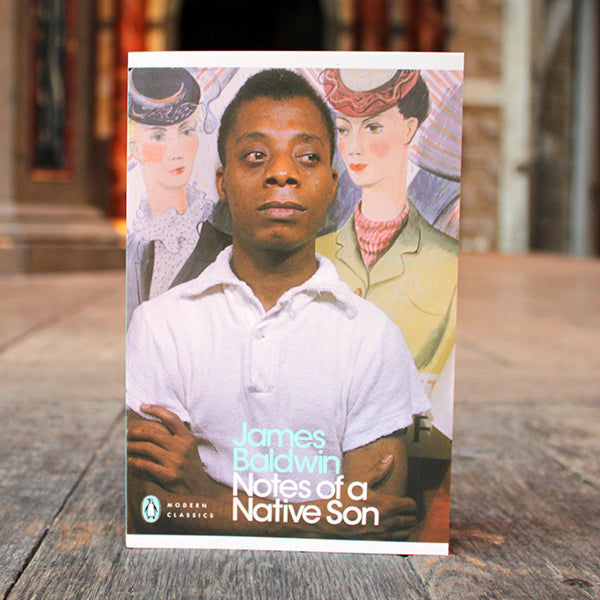 Book cover of 'Notes of a Native Son' by James Baldwin on a wooden surface.