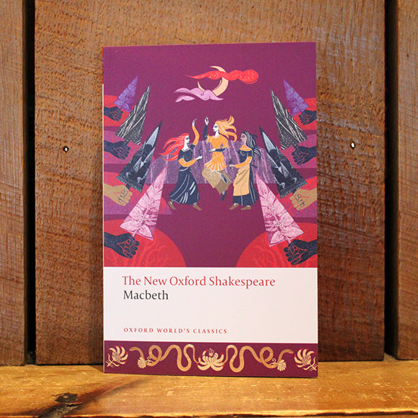 Paperback book with purple colour and yellow, orange and grey images of 3 witches dancing under the moon