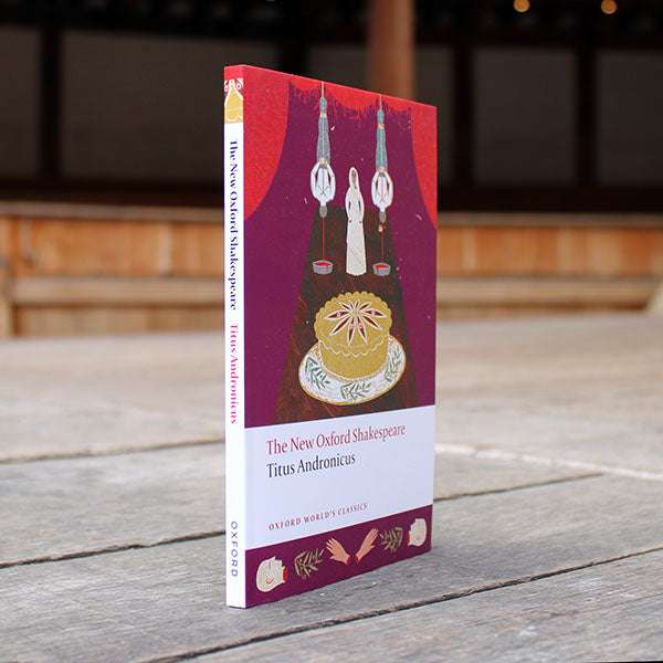 paperback book with a purple cover sitting on a wooden surface