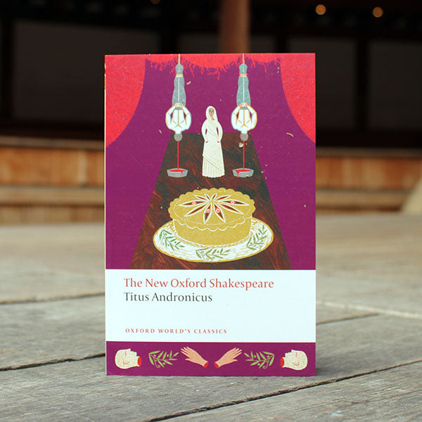 paperback book with a purple cover sitting on a wooden surface
