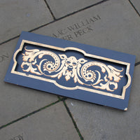 Decorative wooden panel with intricate designs on a stone surface