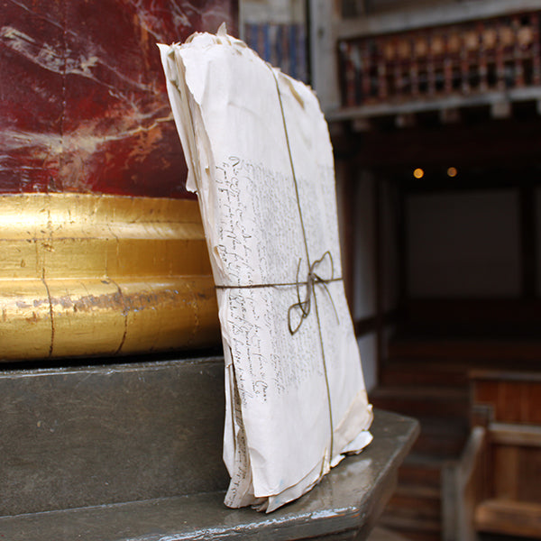 papers with text tied with string on a wooden surface