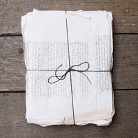 Folded paper with text tied with string on a wooden surface