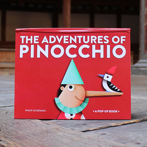 a book titled 'The Adventures of Pinocchio' with a red cover