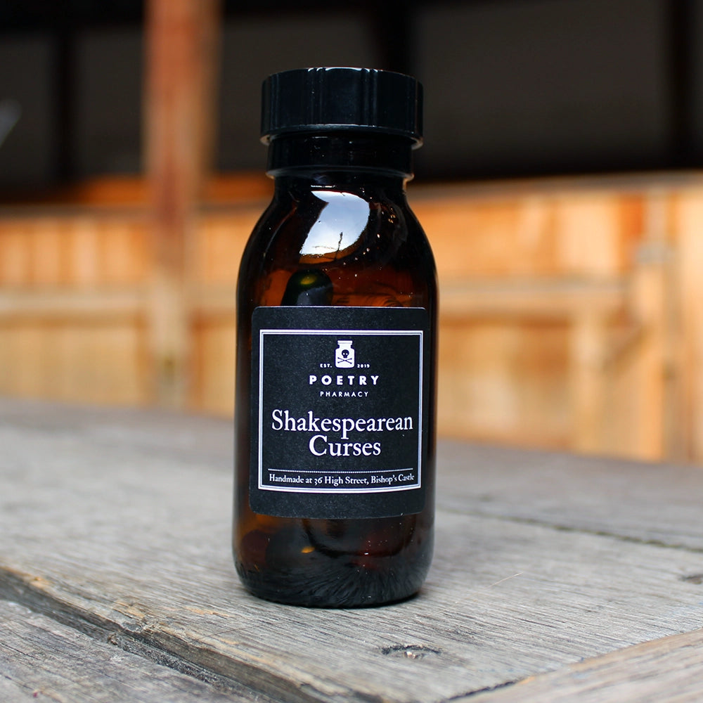 
                  
                    Brown pill bottle with black lid and black label with white writing on it, filled with multicoloured pill poems
                  
                