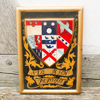 Framed coat of arms with decorative elements on a wooden background