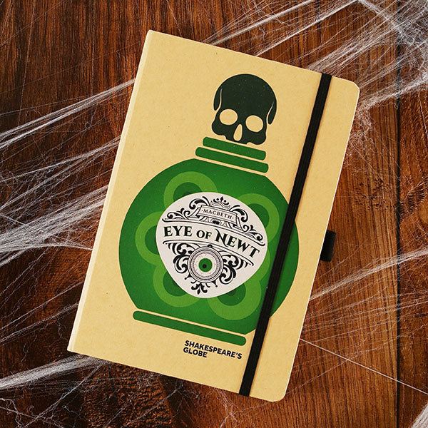 kraft notebook printed on the cover with a green potion bottle with an ornate white label 