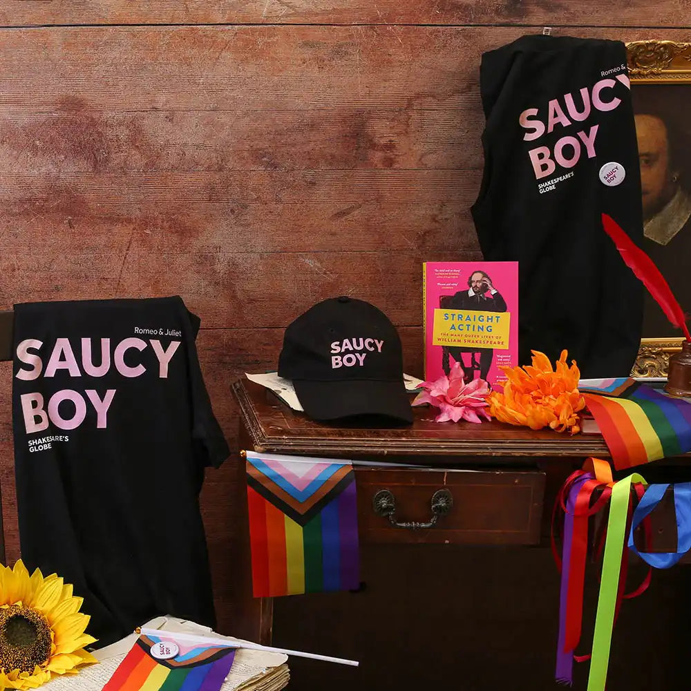 Display of 'Saucy Boy' merchandise with books and decorative items on a wooden surface.