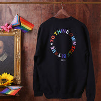 Black sweatshirt with colorful text design on a wooden wall background