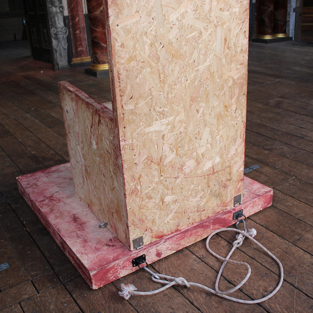 
                  
                    Chipboard throne from Richard III production at Shakespeare's Globe 2024, throne has jagged cut top and is mounted on chipboard base
                  
                