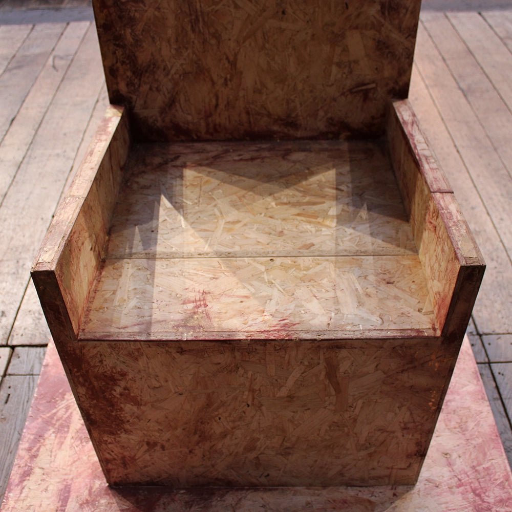 
                  
                    Chipboard throne from Richard III production at Shakespeare's Globe 2024, throne has jagged cut top and is mounted on chipboard base
                  
                