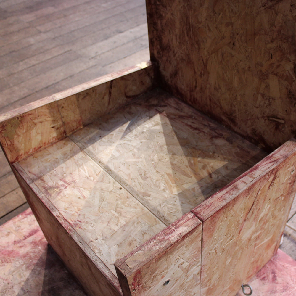 
                  
                    Chipboard throne from Richard III production at Shakespeare's Globe 2024, throne has jagged cut top and is mounted on chipboard base
                  
                