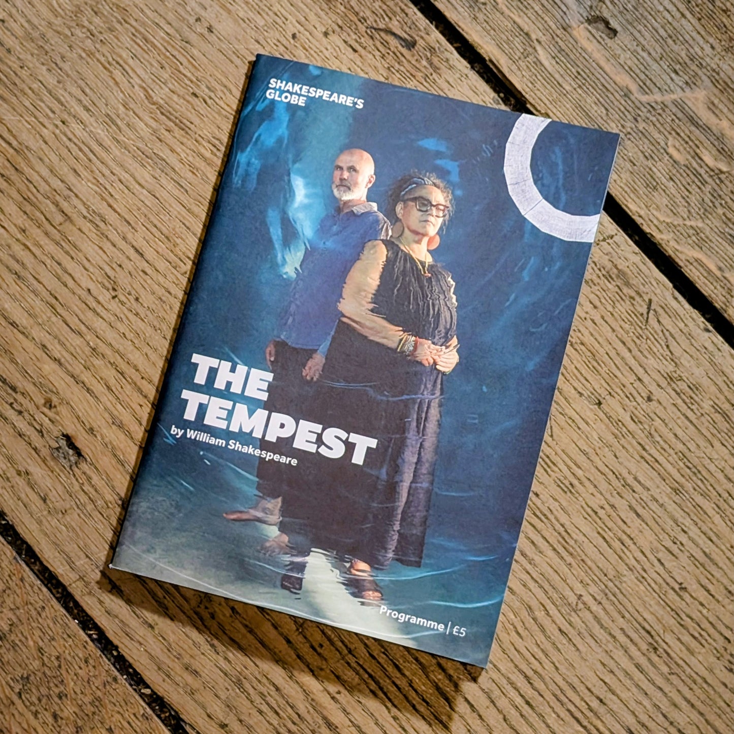 Book titled 'The Tempest' by William Shakespeare on a wooden surface