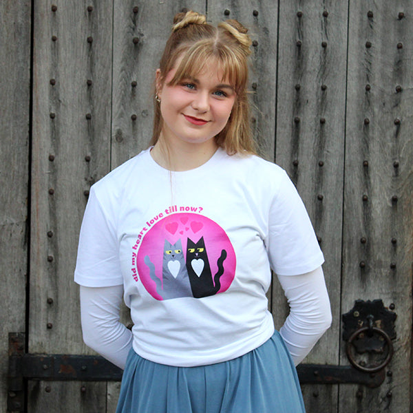 
                      
                        White t-shirt with pink graphic of black and grey cat in the centre
                      
                    