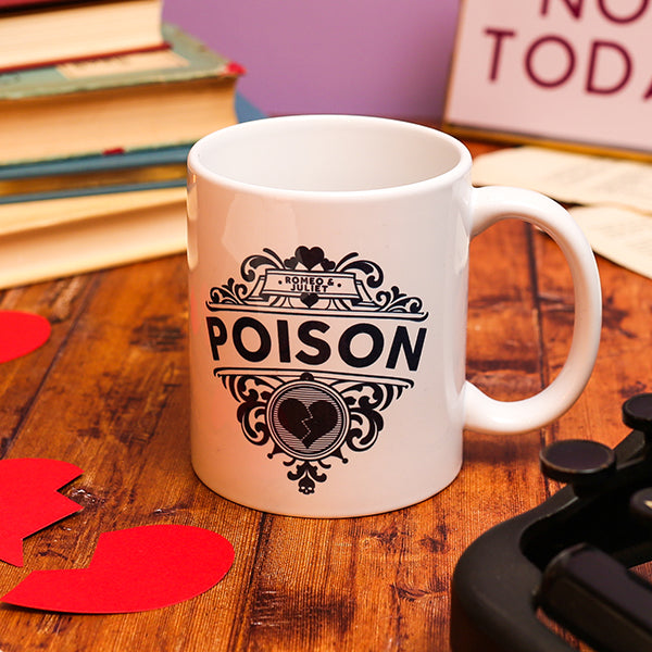 White mug with 'POISON' design on a wooden surface with heart-shaped cutouts and books in the background.