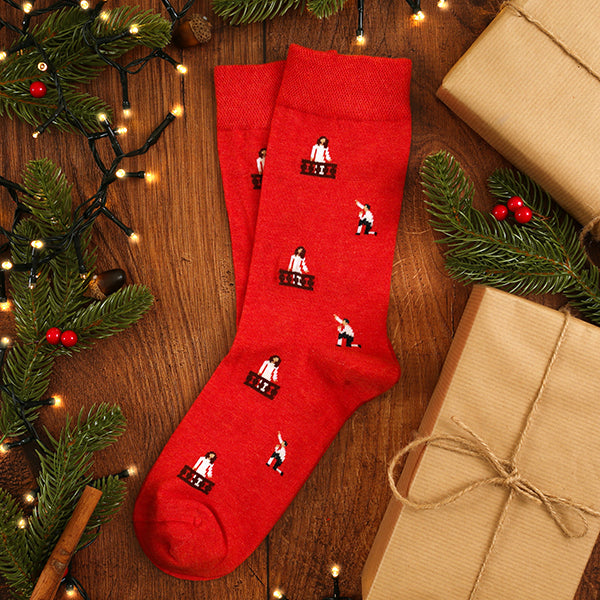Red socks with patterns on a wooden surface with Christmas decorations