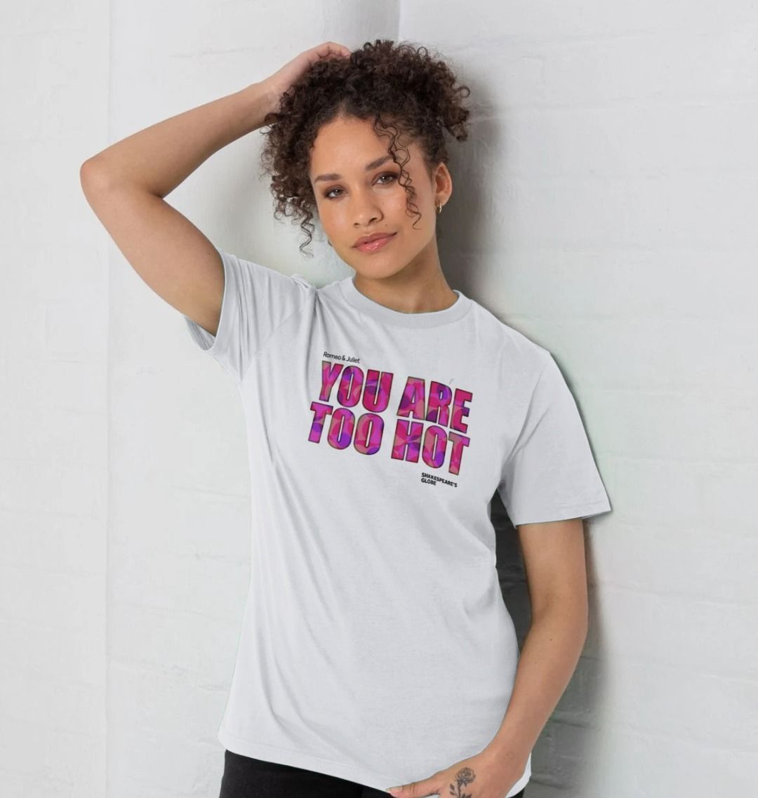 Woman wearing a white t-shirt with colourful text against a plain background