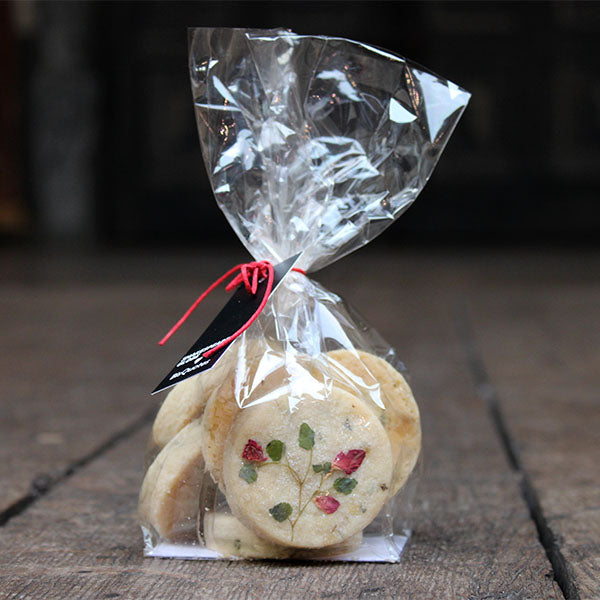Cello bag containing round shortbread biscuits with real flower petal decoration